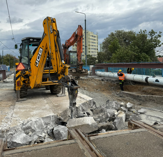 na zdjęciu koparka żółta i rozkopana asfaltowa nawierzchnia mostu