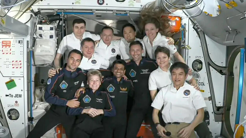 Jedenaście astronautów pozuje do fotografii na Międzynarodowej Stacji Kosmicznej.