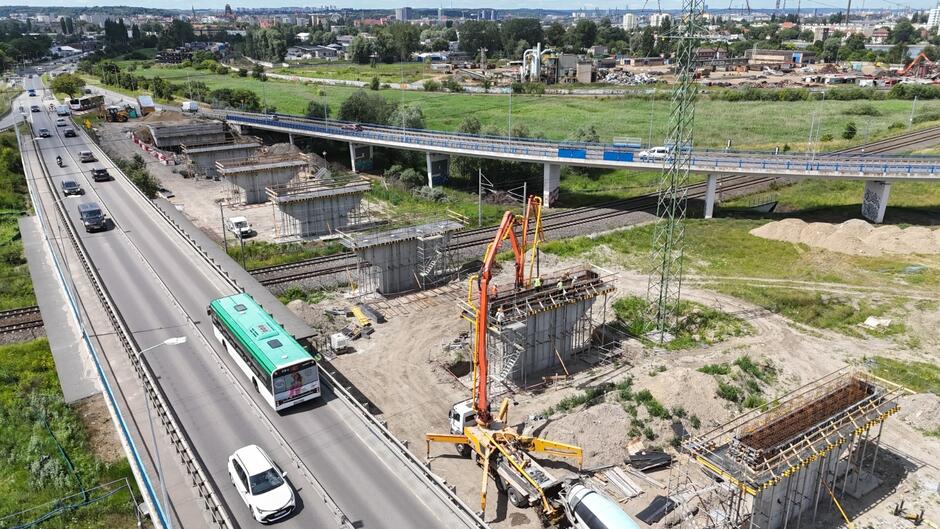 zdjęcie z drona, widać nowe filary mostu stojące w jednym rzędzie, stoi tam też betoniarka