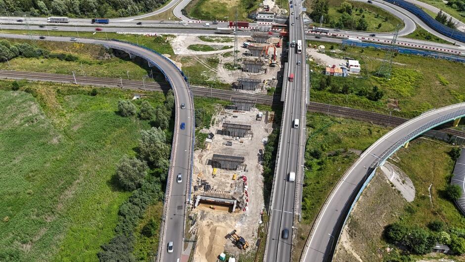 zdjęcie z drona, widać kilka betonowych filarów mostu stojących w jednym rzędzie, obok nich jezdnie sąsiednich estakad