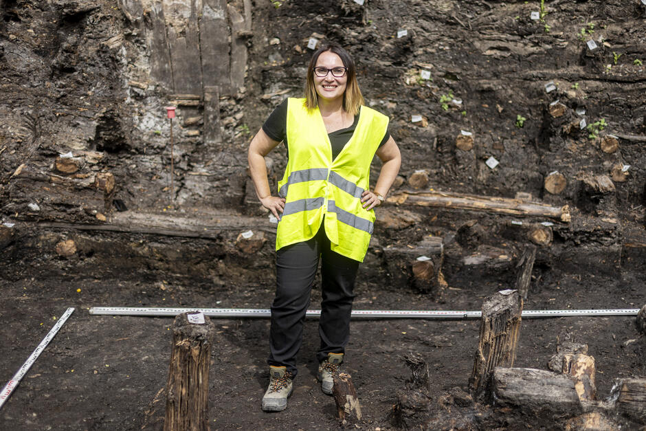 Kobieta lat około 50 pozuje do zdjęcia na tle wykopalisk