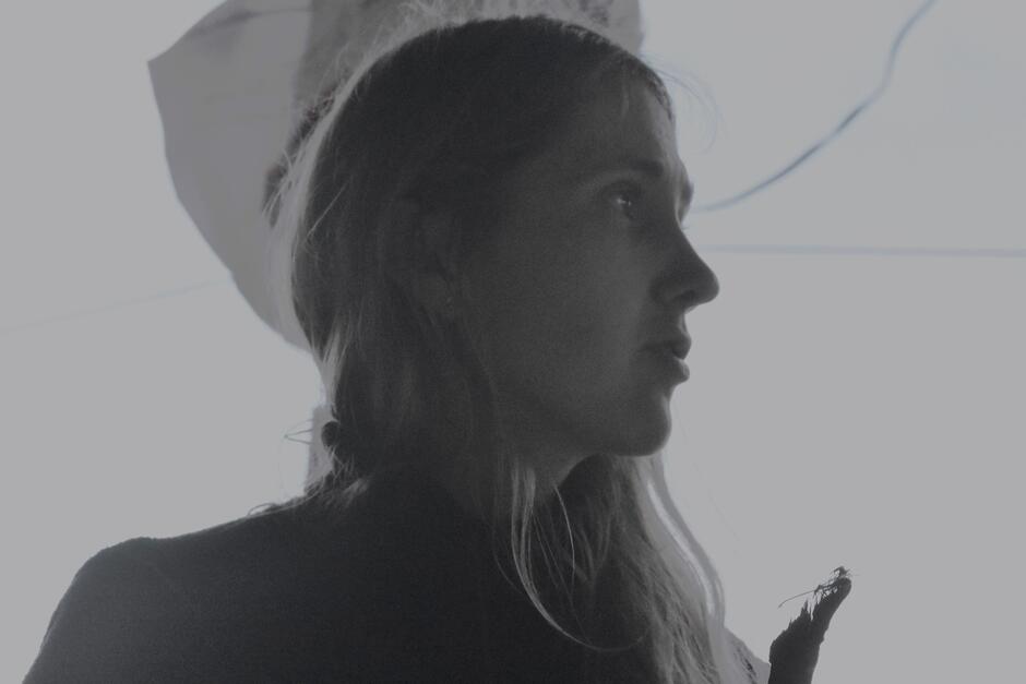 Na zdjęciu kobieta z włosami za ramiona, patrząca w prawą stronę.