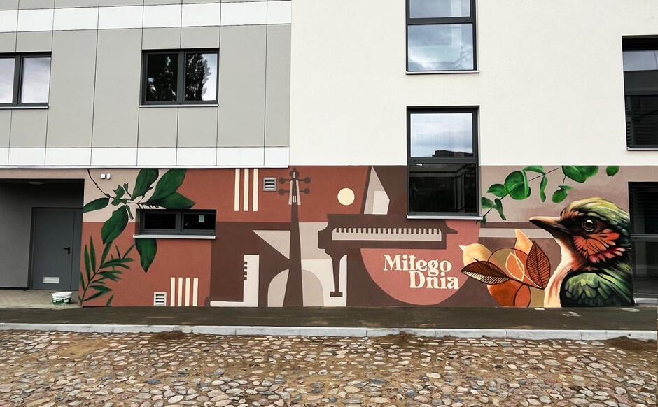 Pokazany jest fragment muralu z realistycznym ptakiem, roślinnością i napisem „Miłego Dnia”, komponujący się z pierwszą częścią. Projekt kończy się spójnym, przyjaznym przekazem wizualnym.