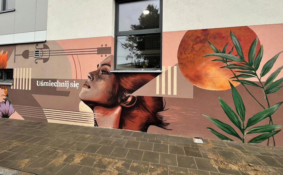 Pokazany jest fragment muralu z realistycznym ptakiem, roślinnością i napisem „Uśmiechnij się”, komponujący się z pierwszą częścią. Projekt kończy się spójnym, przyjaznym przekazem wizualnym.