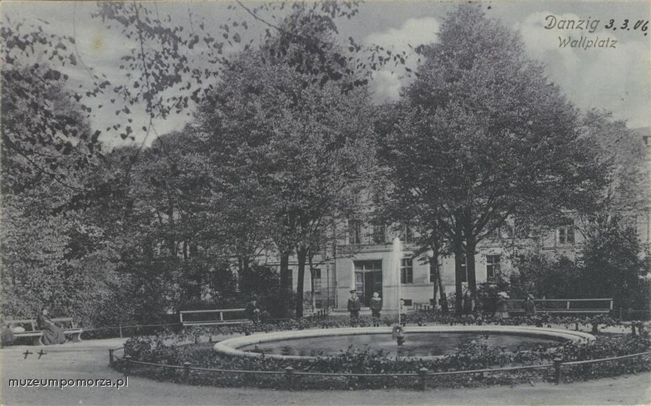 Czarno-biała pocztówka. Parkowe otoczenie z okrągłą fontanną pośrodku