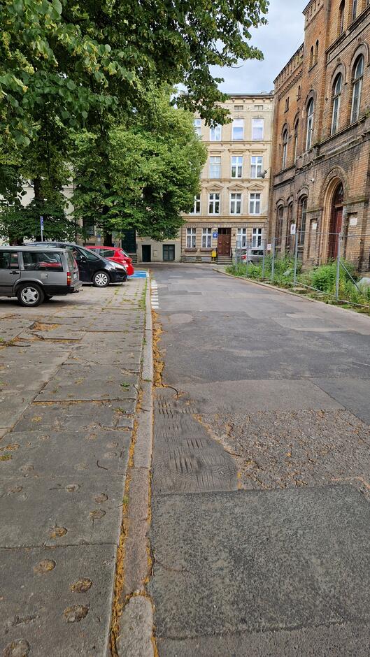 Płyty betonowe, kamienne i asfalt na ulicy przy Placu Wałowym