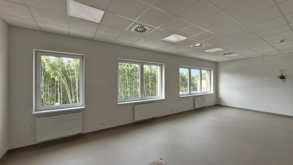 na zdjęciu sala lekcyjna, widać białe ściany i trzy okna