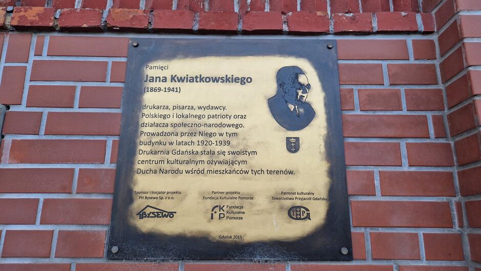Pamięcia Jaqna Kwiatkowskiego (1869-1941) drukarza, pisarza, wydawcy. Polskiego i lokalnego patrioty oraz działacza społeczno-narodowego. Prowadzona przez Niego w tym budynku w latach 1920-1939 Drukarnia Gdańska stała się swoistym centrum kulturalnym ożywiającym Ducha Narodu wśród mieszkańców tych terenów.
