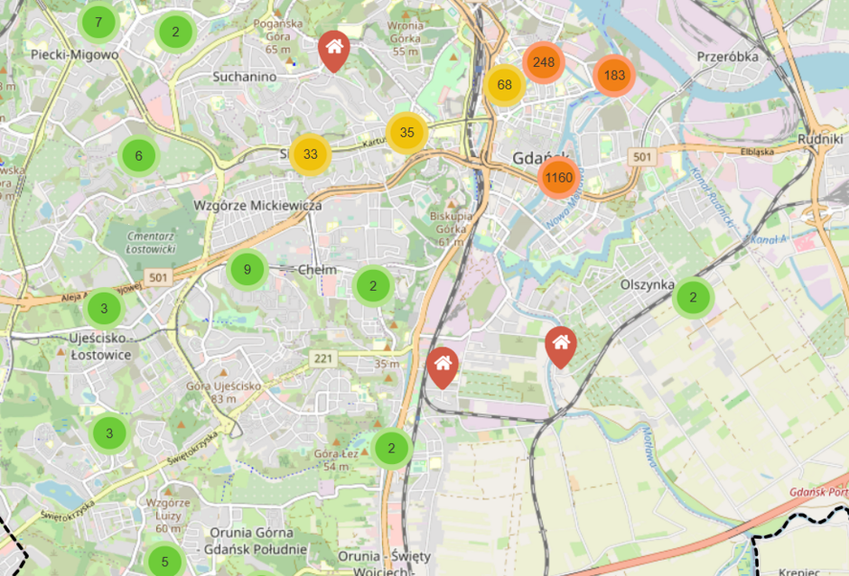 Mapa przedstawia Gdańsk z oznaczeniami liczby dostępnych ofert nieruchomości w różnych dzielnicach miasta. Kolorowe okręgi z liczbami wskazują skupiska ogłoszeń, z największym zagęszczeniem w centrum Gdańska.