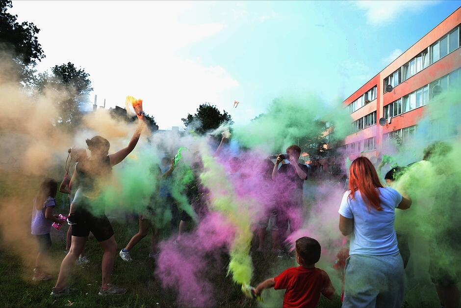 Młodzi ludzie obsypujący się kolorowym proszkami