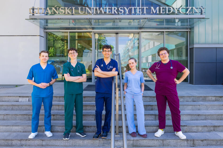 młodzi ludzie stoją przed wejście na uczelnię 