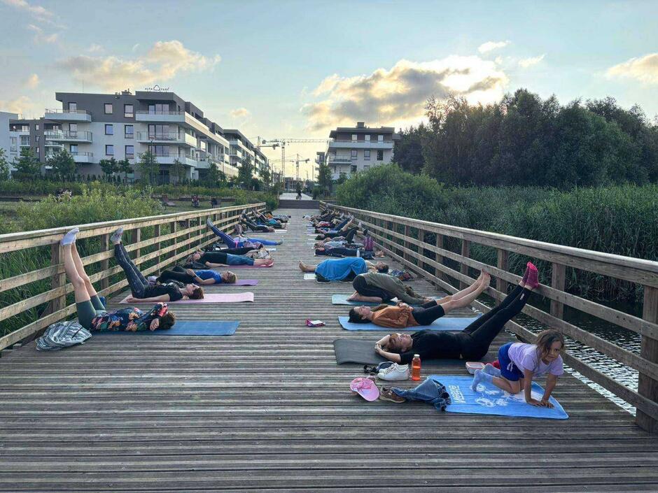 na zdjęciu kilkanaście kobiet leży na pomoście na kolorowych matach