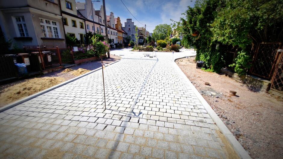 na zdjęciu układana nowa nawierzchnia jezdni wykonana z kostki brukowej