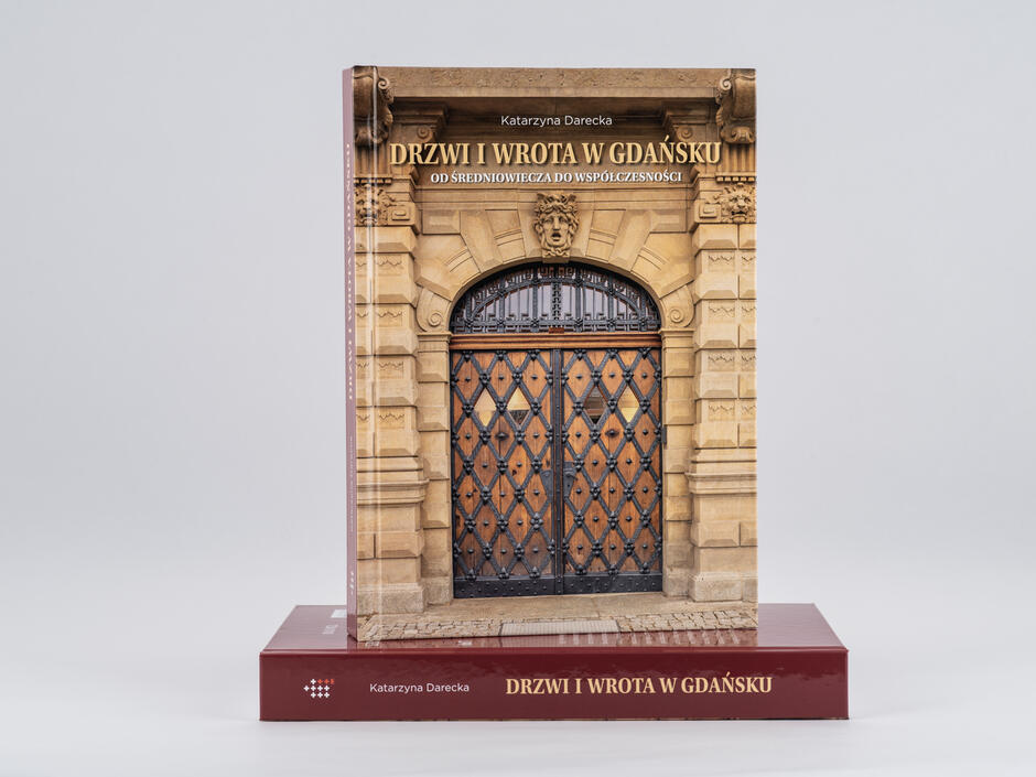 Okładka stojącej i obwoluta leżącej książki „Drzwi i wrota. Od średniowiecza do współczesności”.