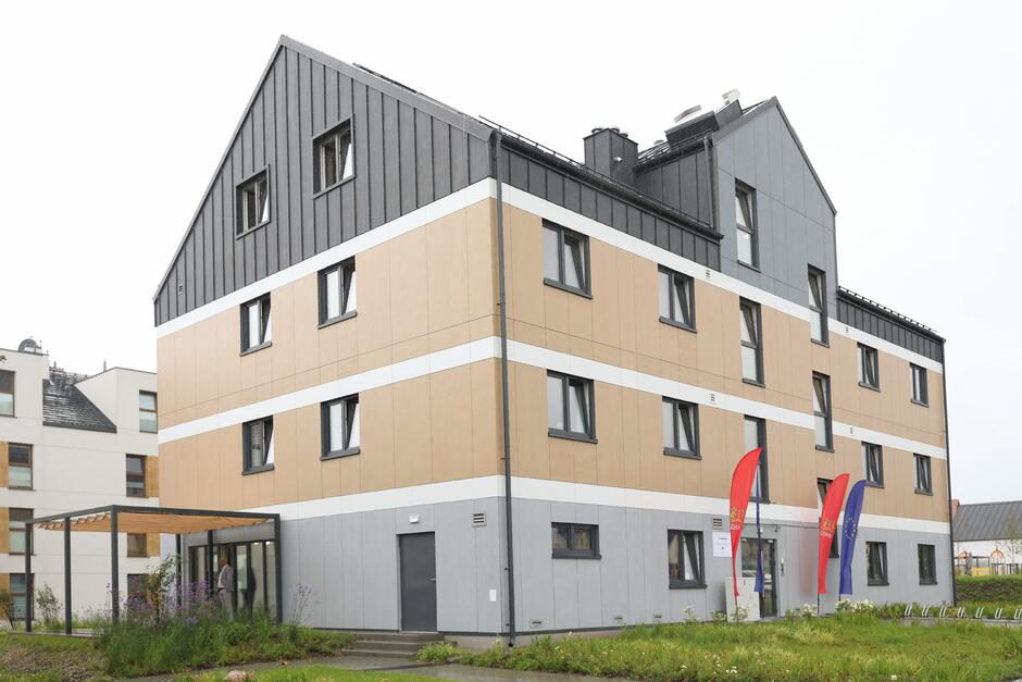 Nowo wybudowany dom z dwoma piętrami i poddaszem.