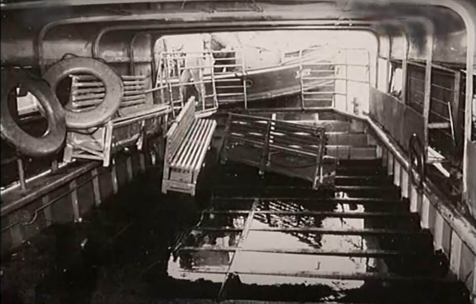 Widać wnętrze budy promowej, a w niej ławy do siedzenia i koła ratunkowe 