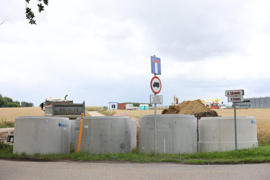 na zdjęciu duże betonowe okrągłe elementy, leżą na ziemi