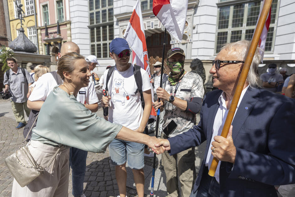Kilka osób podczas manifestacji, w tym kobieta