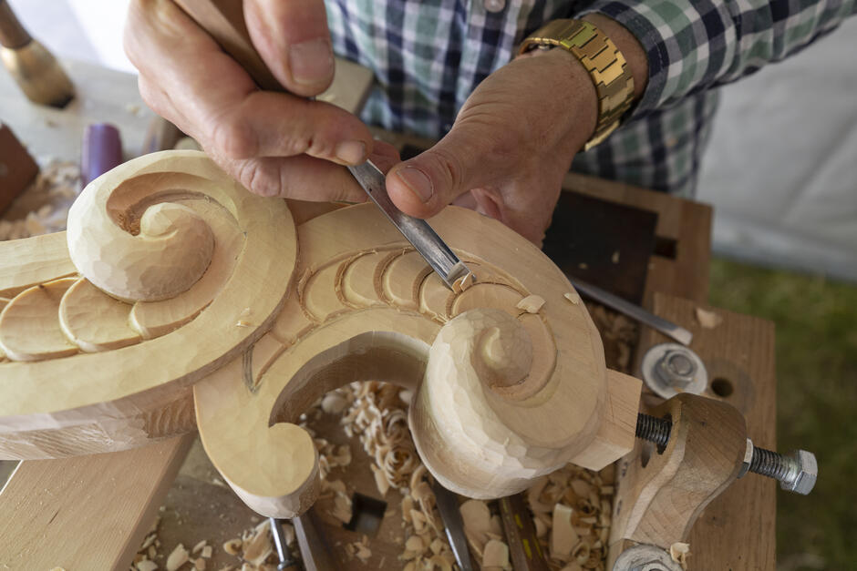 Ręce rzemieślnika, który rzeźbi w drewnie