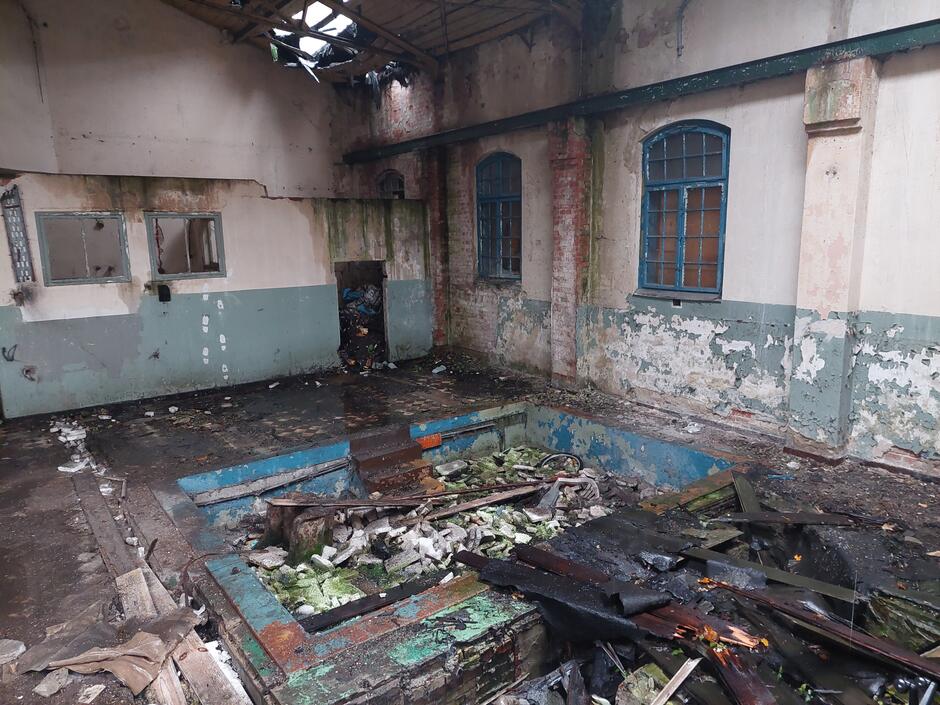 Odrapane wnętrze budynku pełne śmieci
