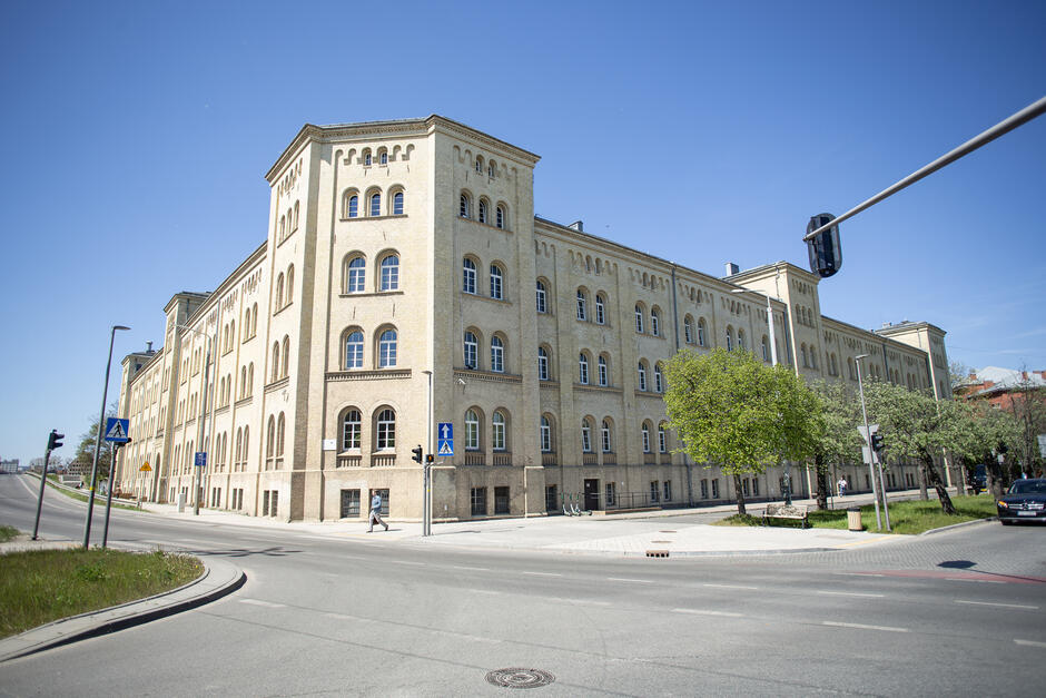 na zdjęciu zabytkowy jasny budynek stojący przy ulicy