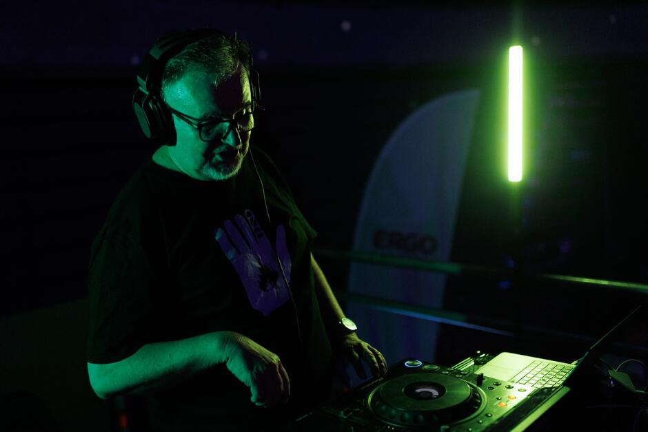 Mężczyzna po pięćdziesiątce przy konsoli do puszczania muzyki