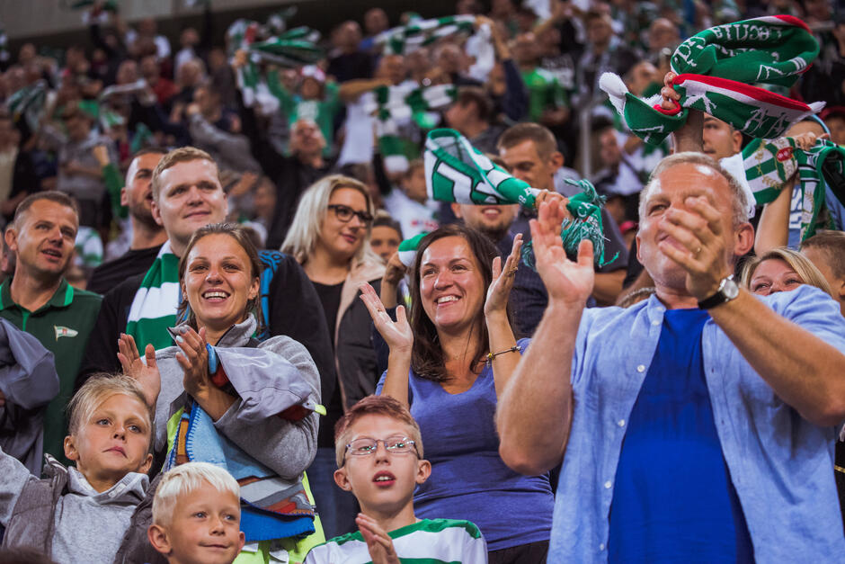 Tłum kibiców na trybunach, w biało-zielonych barwach