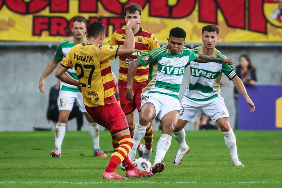 Kilku piłkarzy na boisku w walce o piłkę