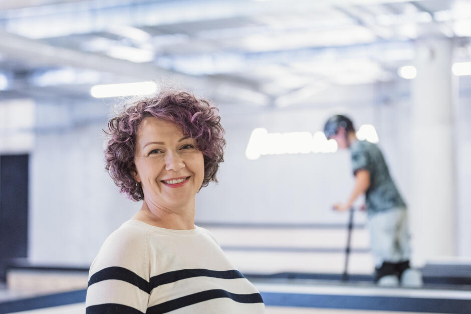 Kobieta pozuje z uśmiechem do zdjęcia w skateparku.