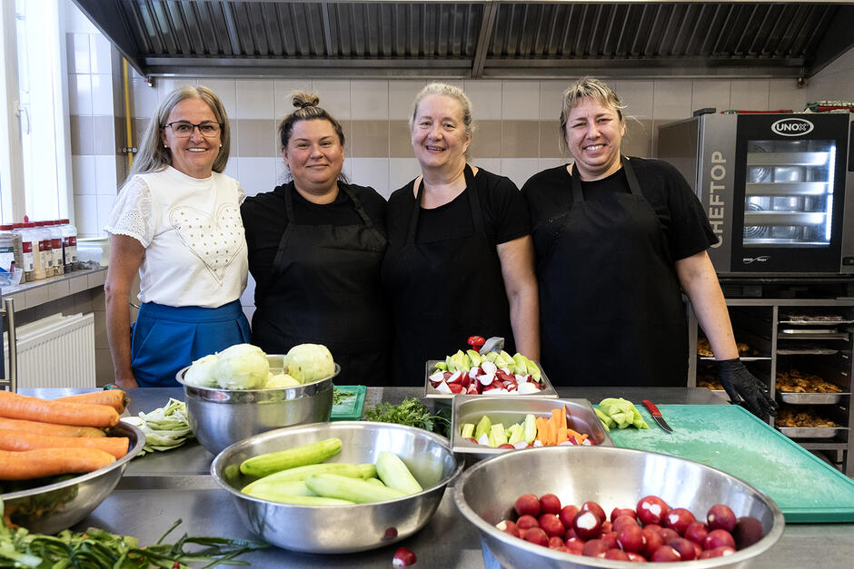 Cztery kobiety, w tym trzy kucharki, pozują do zdjęcia w kuchni.