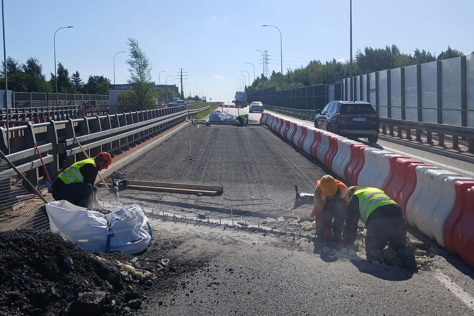 Robotnicy pracują na ulicy przy remoncie nawierzchni. 