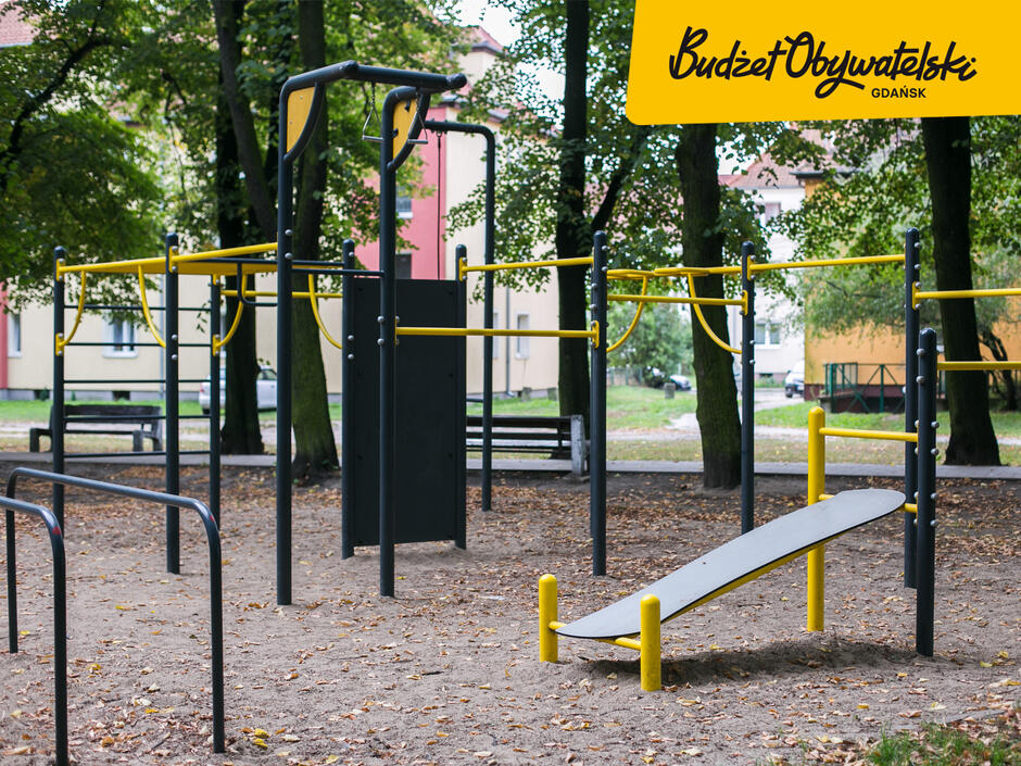 na zdjęciu elementy siłowni plenerowej, w górnym prawym rogu żółta plama z czarnym napisem budżet obywatelski