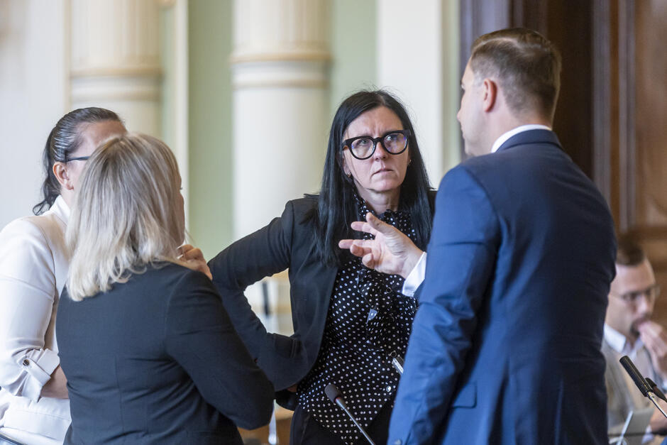 Kobieta rozmawia z mężczyzną i kobietą w radzie Miasta Gdańska.