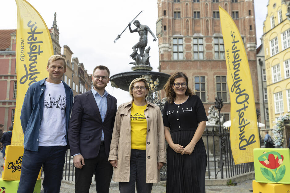 na zdjęciu dwie kobiety po prawej i dwóch młodych mężczyzn po lewej, wszyscy stoją w jednym rzędzie, pozują do zdjęcia