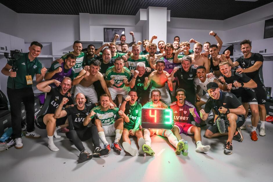 Wspólne zdjęcie całej drużyny Lechii, zrobione w szatni po meczu w Szczecinie. Piłkarze pozują z tablicą świetlną na której jest wynik 4:3