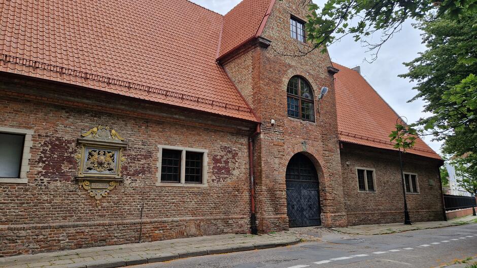 Ceglany budynek ze spadzistym czerwonym dachem