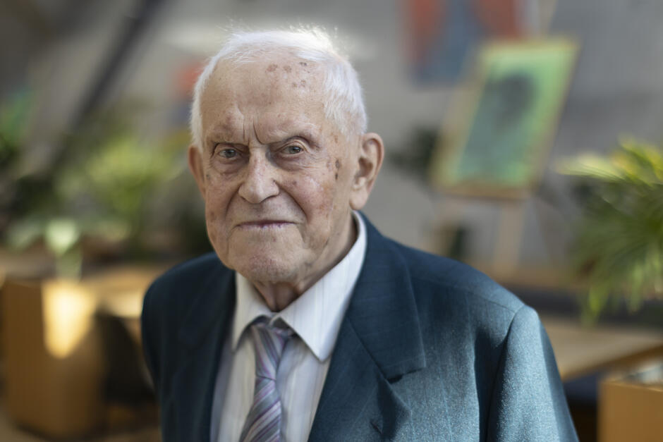 Mężczyzna w podeszłym wieku pozuje do zdjęcia.