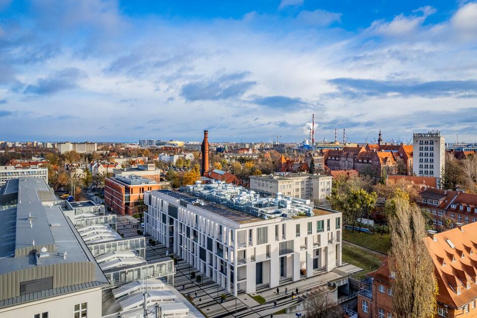 Zdjęcie z lotu ptaka, widok na nowoczesny budynek w mieście pośród starej architektury.