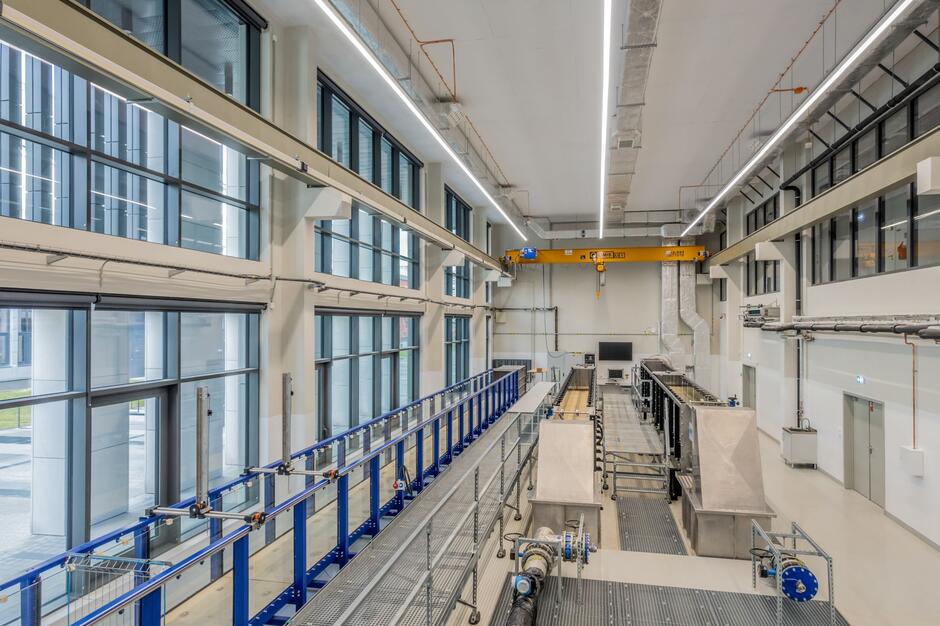 Przeszklone wnętrze nowoczesnego budynku, hala z rurami i systemami.