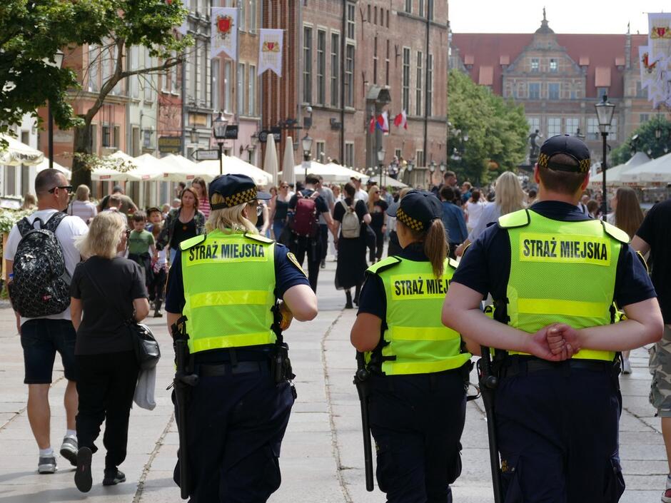 Patrol straży miejskiej na ulicy zatłoczonego miasta.