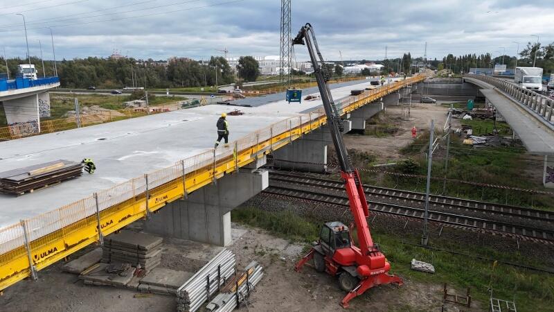 na zdjęciu po lewej fragment betonowanego mostu, po prawej czarno-czerwony dźwig