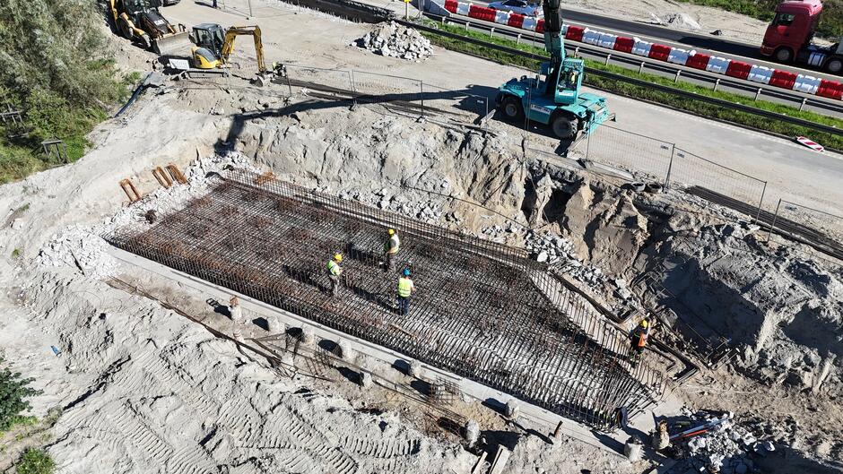 na zdjęciu plac budowy, widać metalowe elementy konstrukcji i robotników