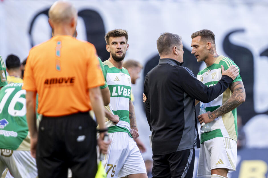 Kilku piłkarzy z trenerem, przy płycie bocznej boiska