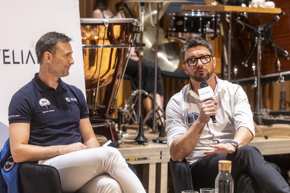 Dwóch mężczyzn rozmawia na scenie.