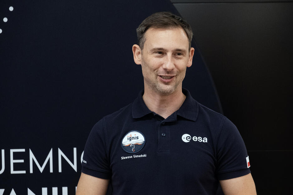 Mężczyzna w koszulce polo z napisem Sławosz Uznański.