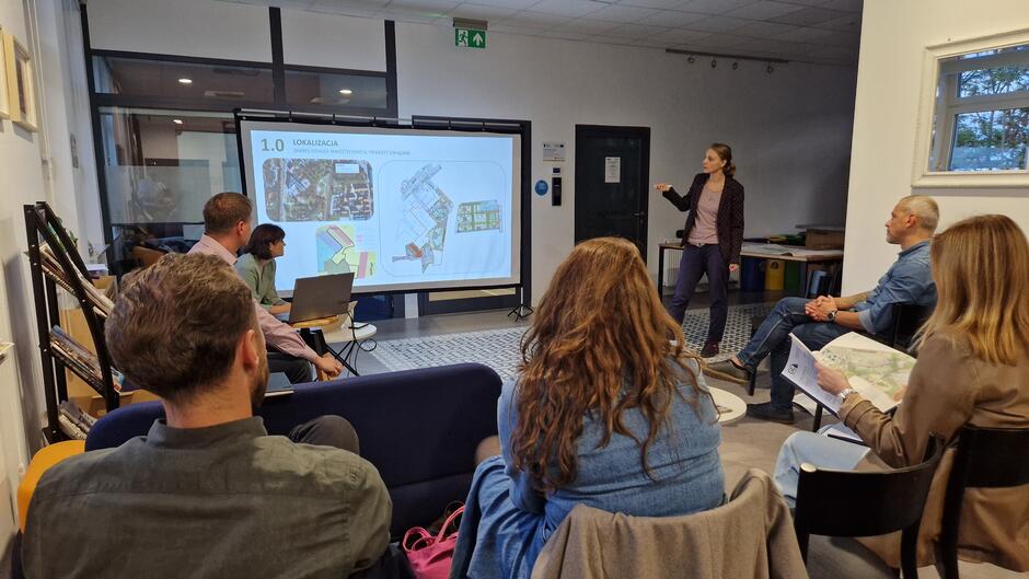 Sala z ludźmi patrzącymi na z wyświetlaną prezentację 