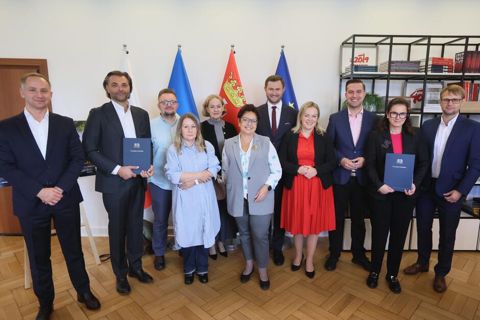 zdjęcie grupowe, pamiątkowe, pozuje kilkanaście osób w oficjalnych strojach