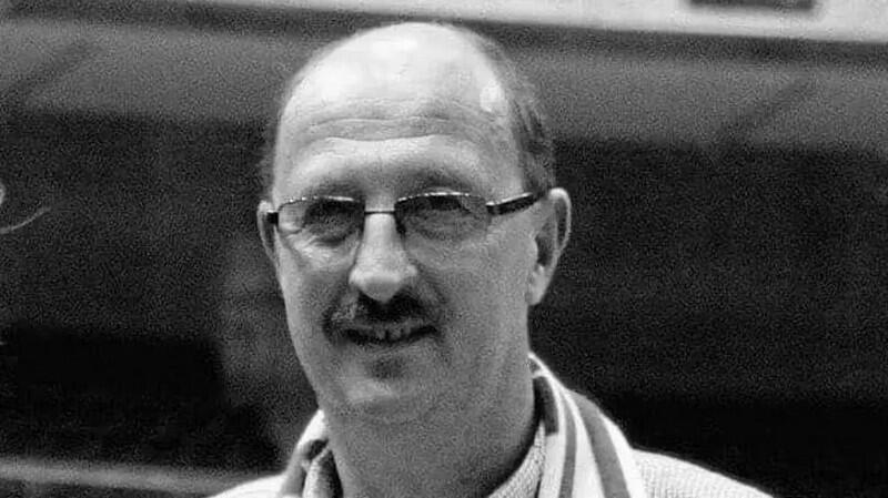 Czarno-białe zdjęcie. Twarz łysiejącego mężczyzny w średnim wieku w okularach