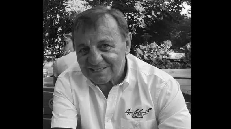 Czarno-białe zdjęcie. Twarz uśmiechniętego mężczyzny w średnim wieku