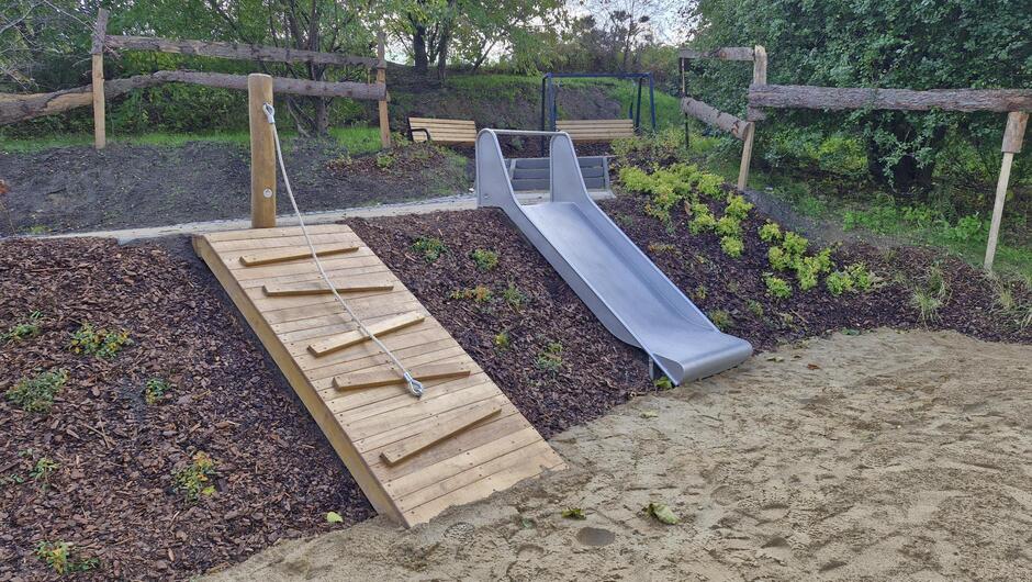 na zdjęciu zjeżdżalnia i ścianka wspinaczkowa dla dzieci w parku